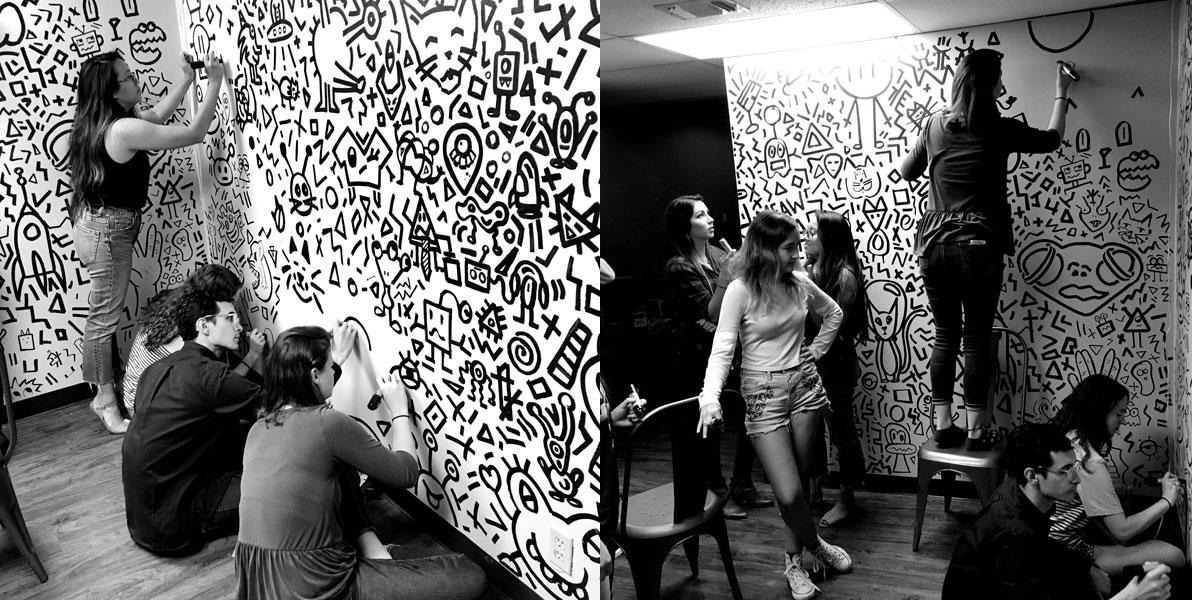 Graphic Design students covering a wall with art